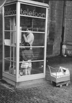 501594 Afbeelding van twee meisjes in de telefooncel op het Domplein te Utrecht.